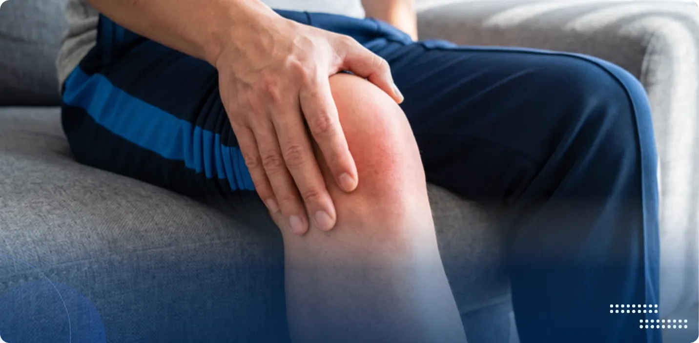Person seated on a sofa holding a sore, reddened knee