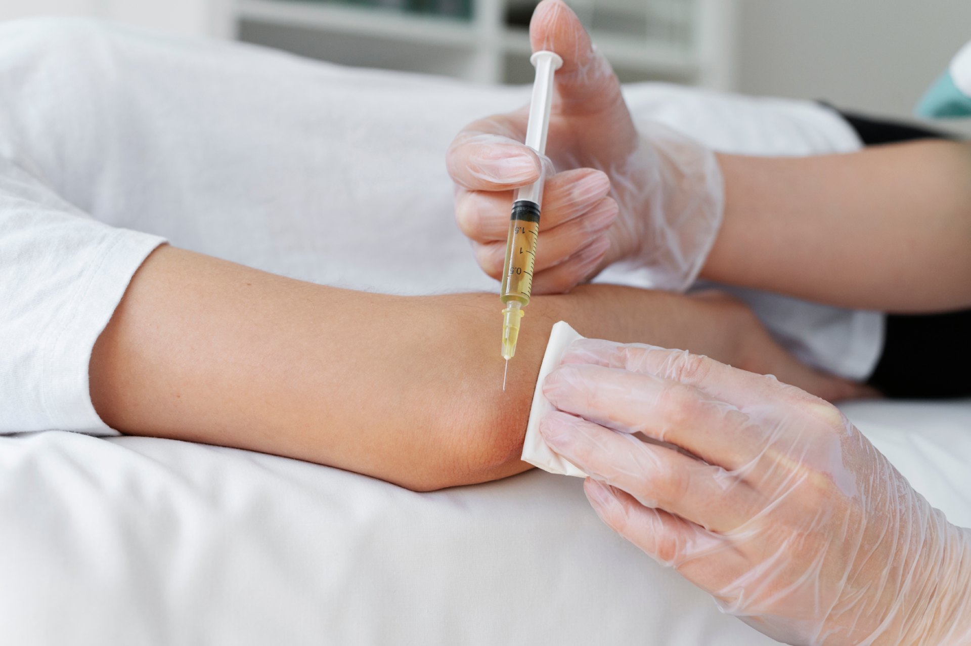Gloved hands preparing a PRP injection for a musculoskeletal treatment